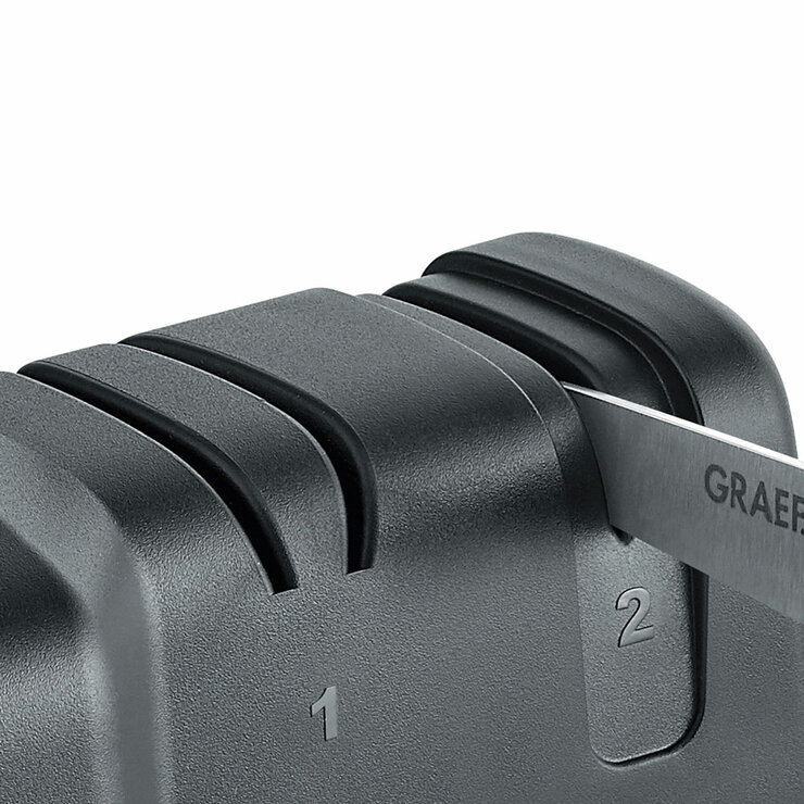 Close up of GRAEF knife sharpener sharpening knife Close up of GRAEF knife sharpener sharpening knife