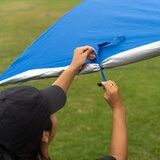 Lifestyle image of someone tying the side panel