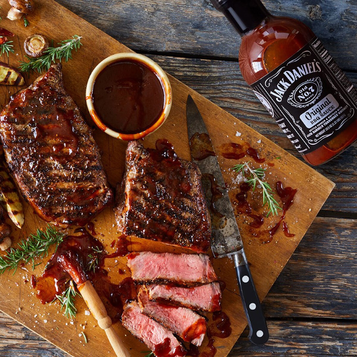 Bottle lying on a Table next to a Glazed Steak