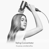 Lifestyle image of a model using Dyson Supersonic Hair Dryer's styling concentrator attachment