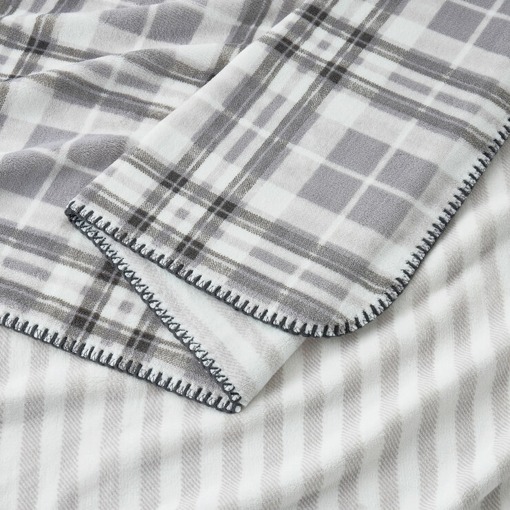 Grey floral throw zoomed in, soft plush look with outer edge thread trimming