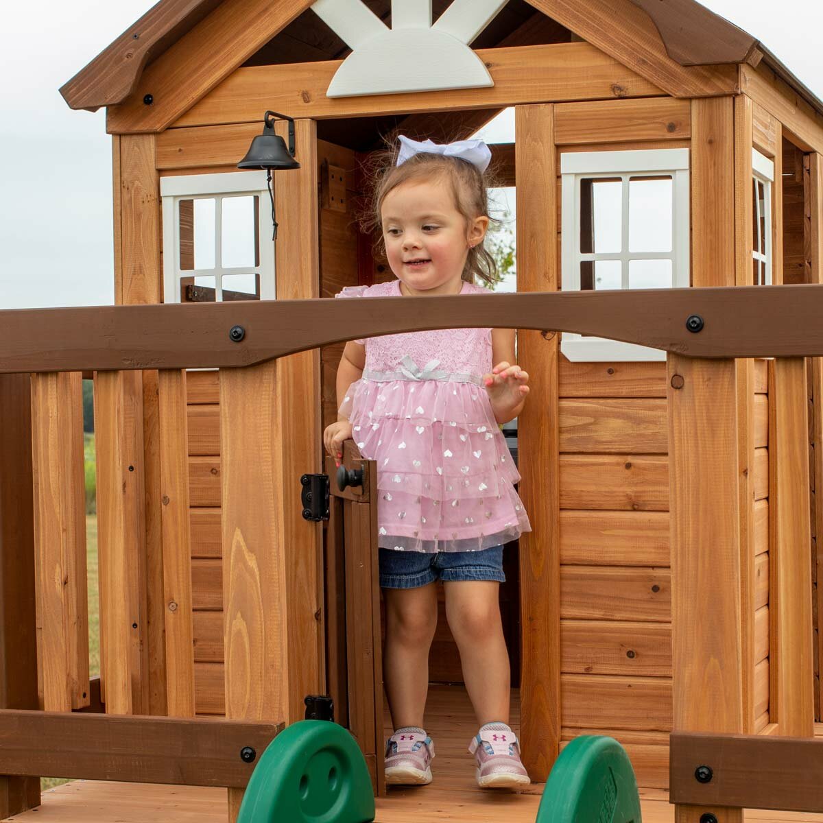 Lifestyle image of a child coming out of the playhouse
