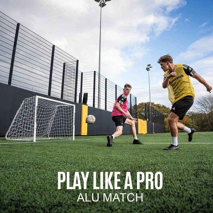 Lifestyle image showing two people playing football using the goal