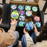 Lifestyle image showing two people looking at the different footballs in the box