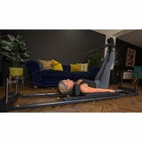 Lifestyle image of a woman using the reformer Lifestyle image of a woman using the reformer
