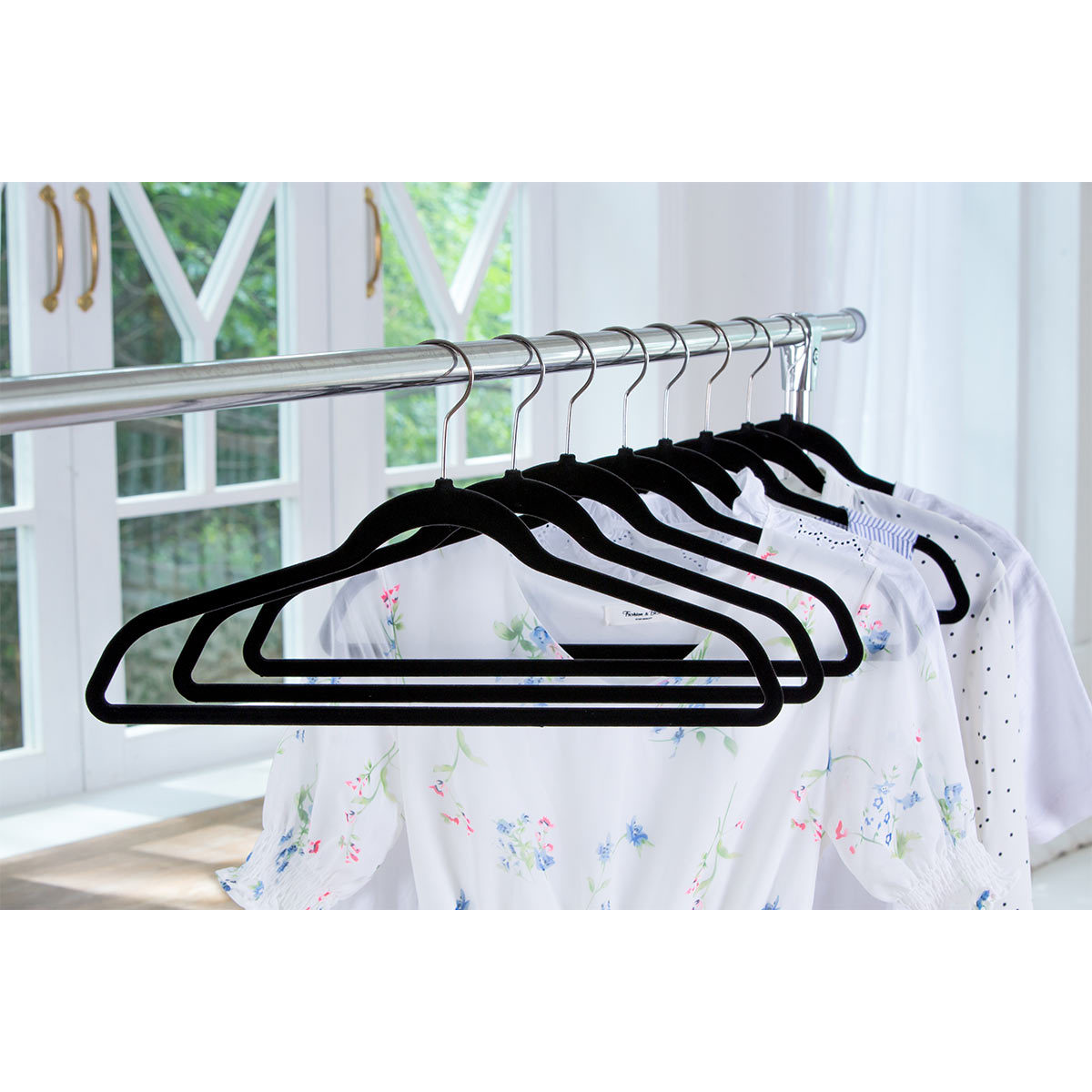 Hangers with white clothes on on a silver rail