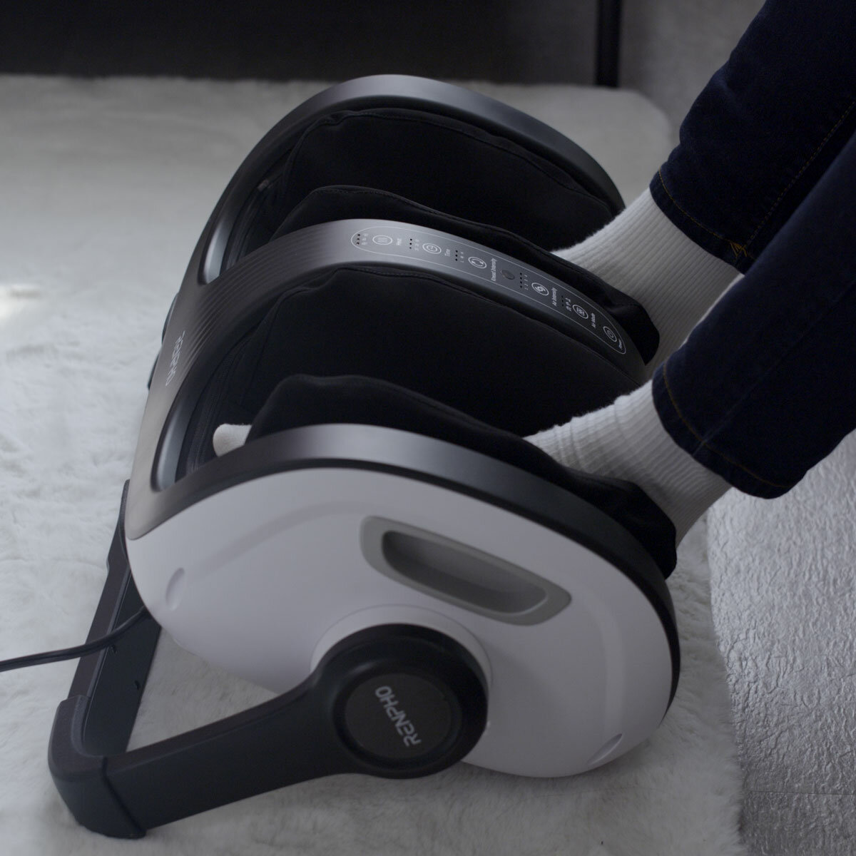 Lifestyle image of model usingt the massager on their feet