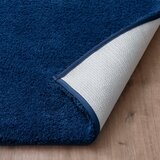 Zommed in imagery of Blue bath mat folded showcasing anti skid backing