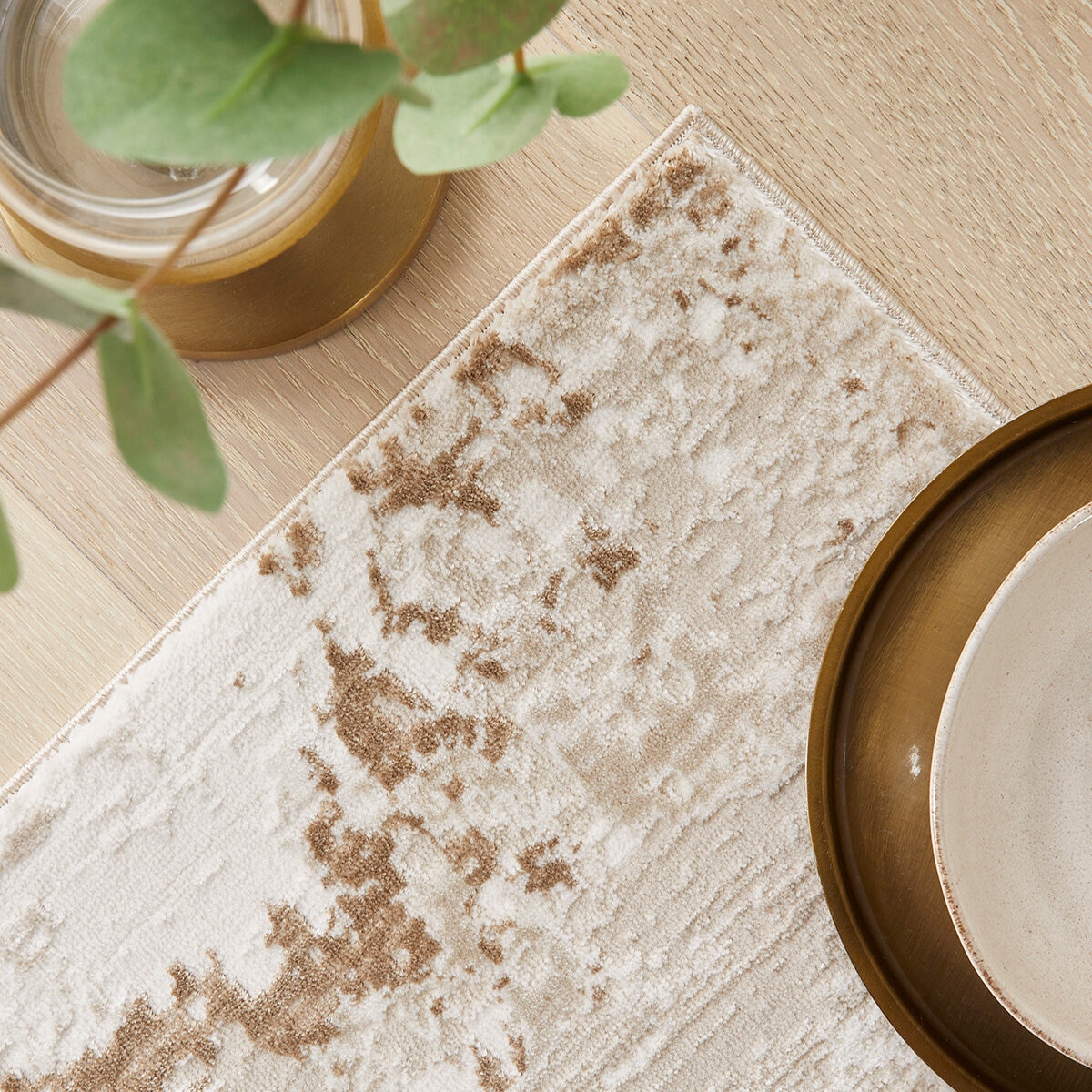 Textured rug with a distressed abstract pattern in beige, cream and light brown, showing irregular brushstroke-style detailing. Textured rug with a distressed abstract pattern in beige, cream and light brown, showing irregular brushstroke-style detailing.