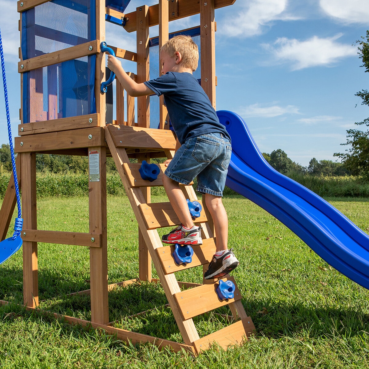 Lifestyle image of a child climbing the rock wall ladder