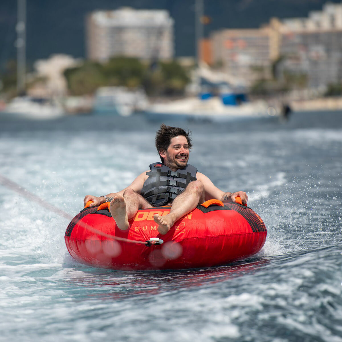 Lifestyle image of a man riding the Jobe Rumble Towable Lifestyle image of a man riding the Jobe Rumble Towable