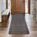 Runner rug with grey geometric pattern on wooden floor in hallway
