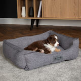 Lifestyle image of dog sitting on pet bed in living room setting