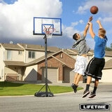 Lifestyle image of two people playing basketball with the Lifetime 48 Inch Portable Basketball Hoop in the background
