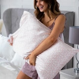 Large light pink and white leopard print pillow held in a bedroom setting with white bedding Large light pink and white leopard print pillow held in a bedroom setting with white bedding