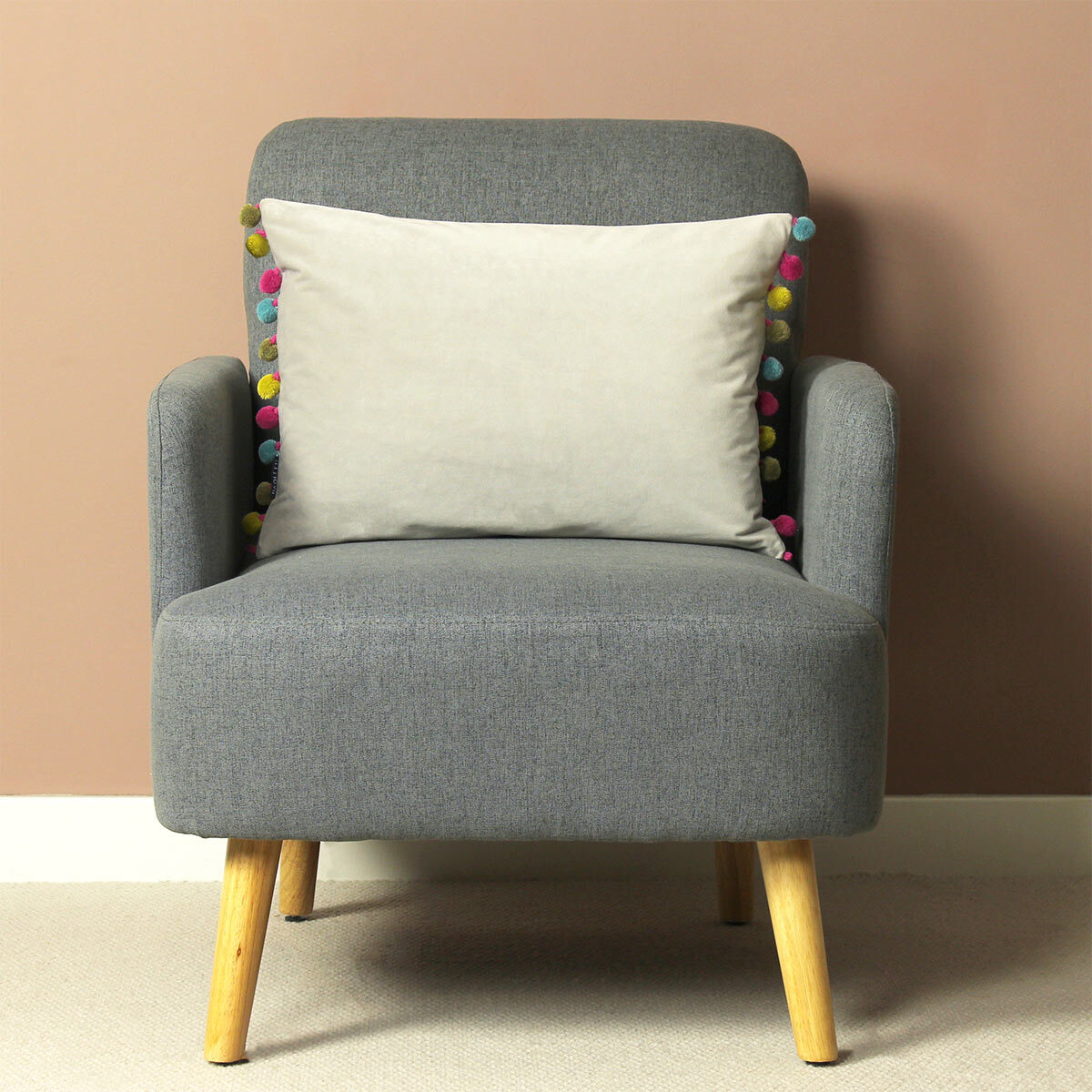 Lifestyle Image of Carnival Velvet Bolster Cushion on Accent Chair