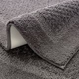 Grey bath mat with a textured surface and non‑slip backing Grey bath mat with a textured surface and non‑slip backing