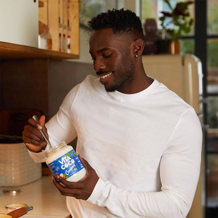 man holding open jar of coconut oil