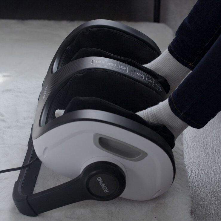 Lifestyle image of model usingt the massager on their feet