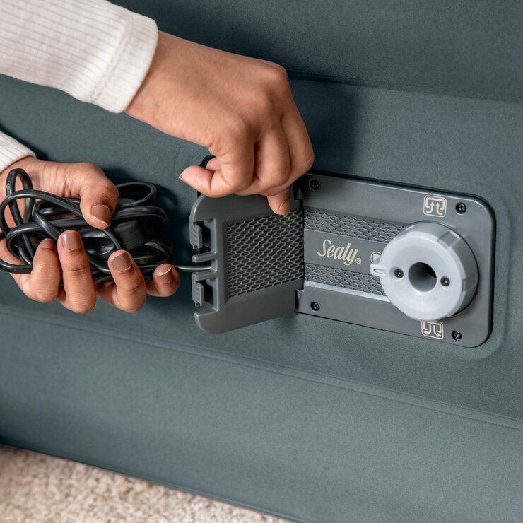 Lifestyle image of a woman taking the electrical plug out of the airbed