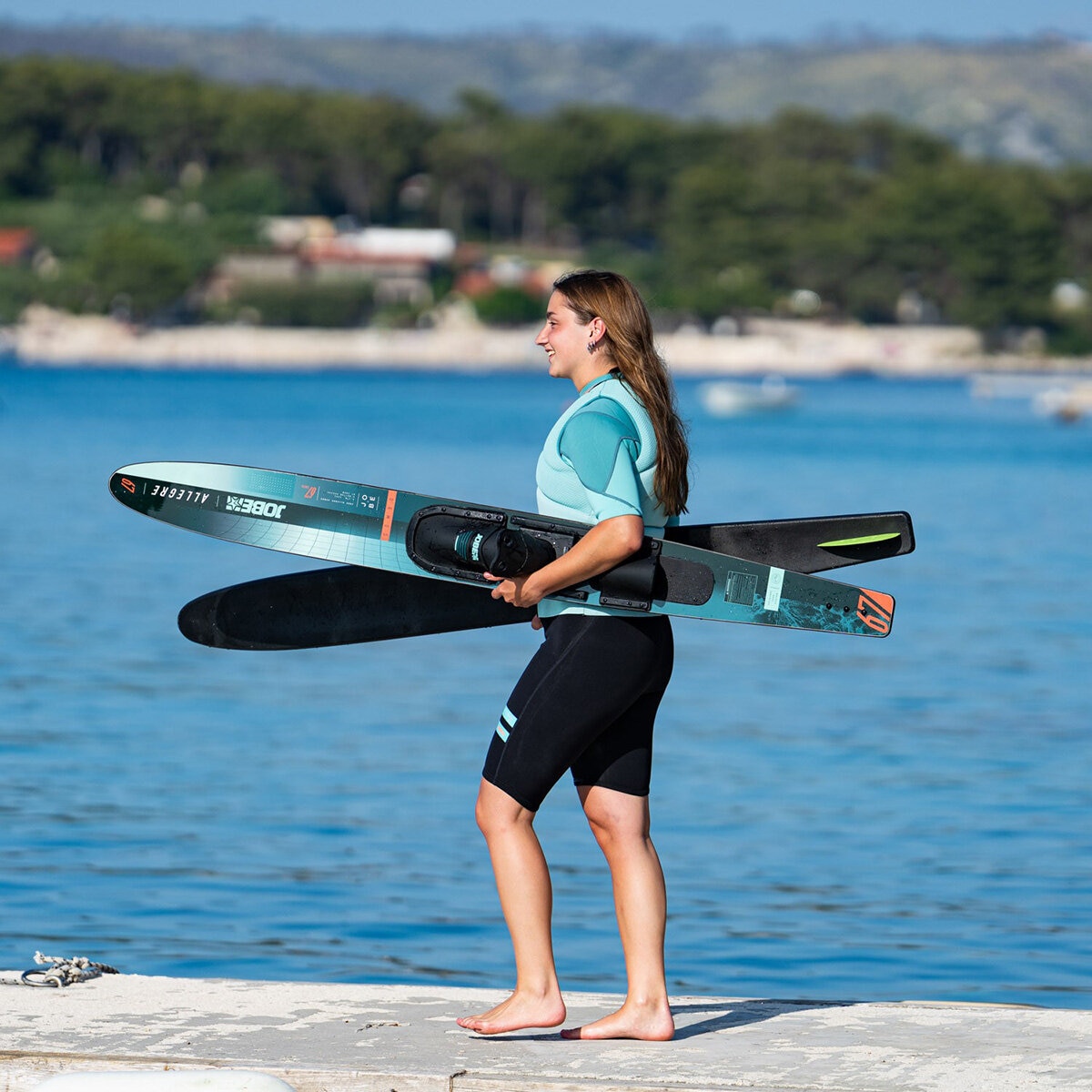 Lifestyle image of a woman carrying the waterskis Lifestyle image of a woman carrying the waterskis