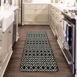 Runner rug with black and white  geometric pattern on wooden floor in hallway