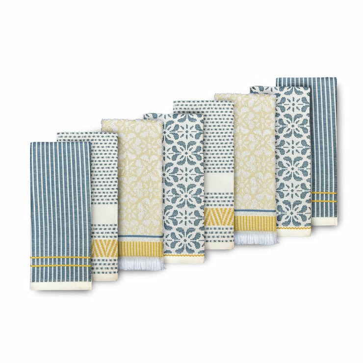 Set of eight folded woven tea towels in blue, white and yellow patterns, neatly arranged to showcase their texture and design with a plain background