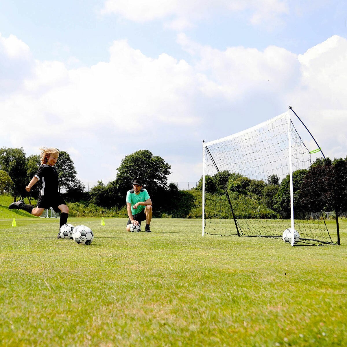 Lifestyle image of a child kicking balls into the goal Lifestyle image of a child kicking balls into the goal
