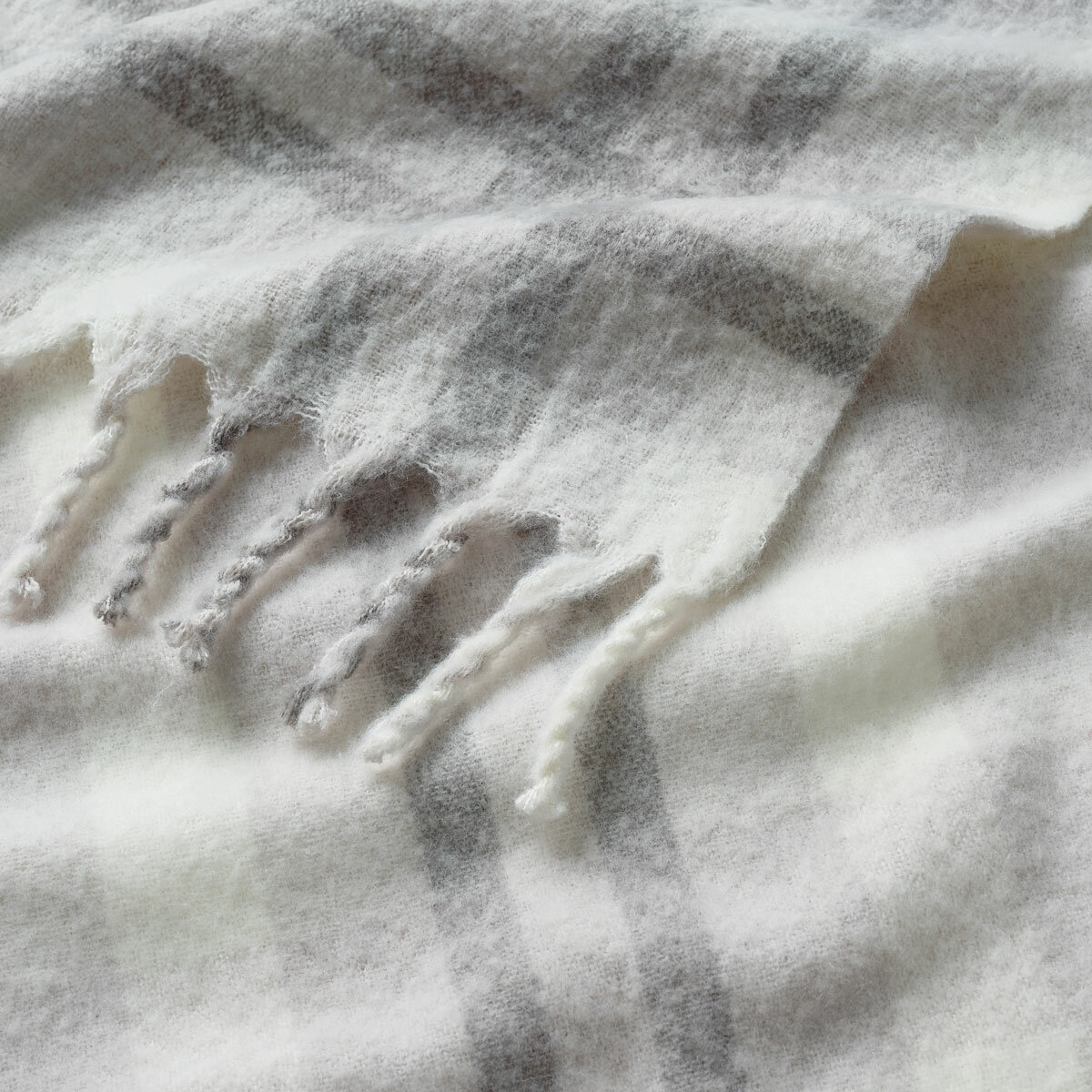 Close up of Grey Faux Mohair Throw, showcasing fringed border and soft texture Close up of Grey Faux Mohair Throw, showcasing fringed border and soft texture