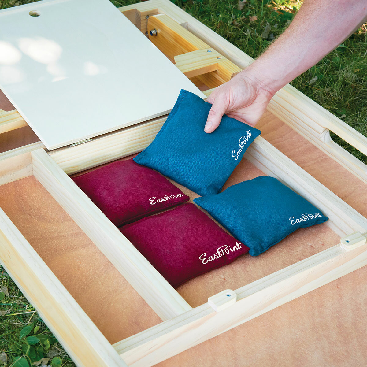 Lifestyle image showing four bean bags being put into the storage compartment