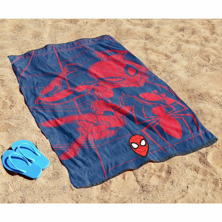 Spiderman character beach towel laid out on sand