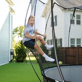 Lifestyle image of a child jumping against the inside of the net Lifestyle image of a child jumping against the inside of the net