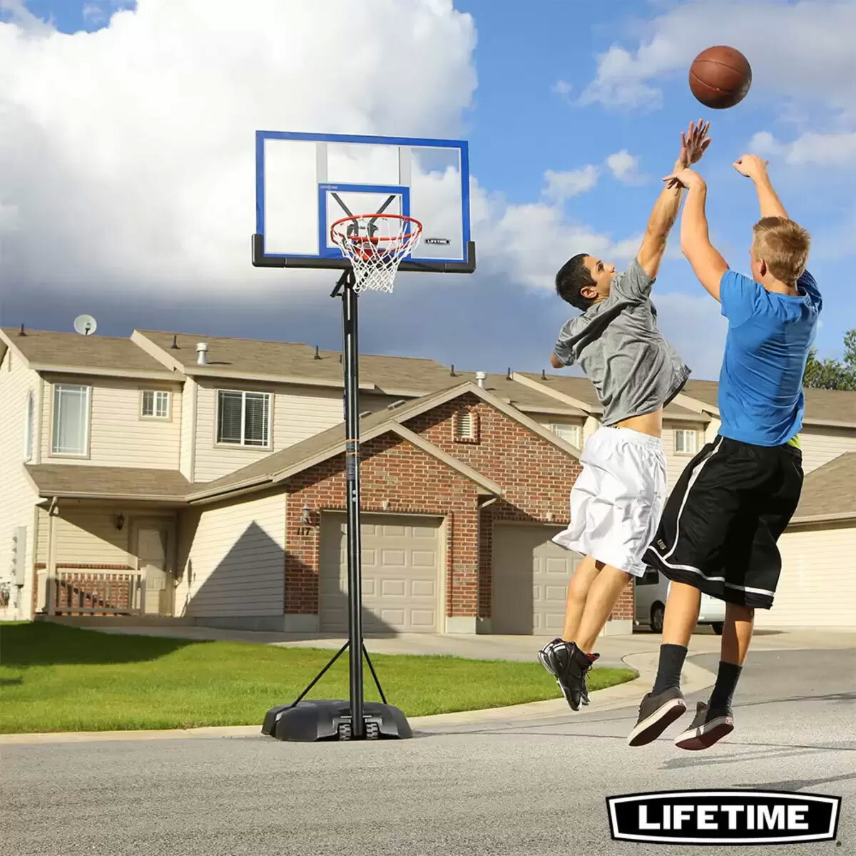 Lifestyle image of two people playing basketball with the Lifetime 48 Inch Portable Basketball Hoop in the background