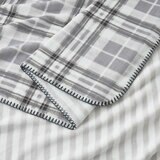 Grey floral throw zoomed in, soft plush look with outer edge thread trimming