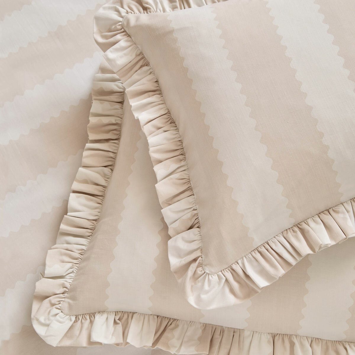 Beige and white striped duvet set with ruffled edges and matching pillow shams.