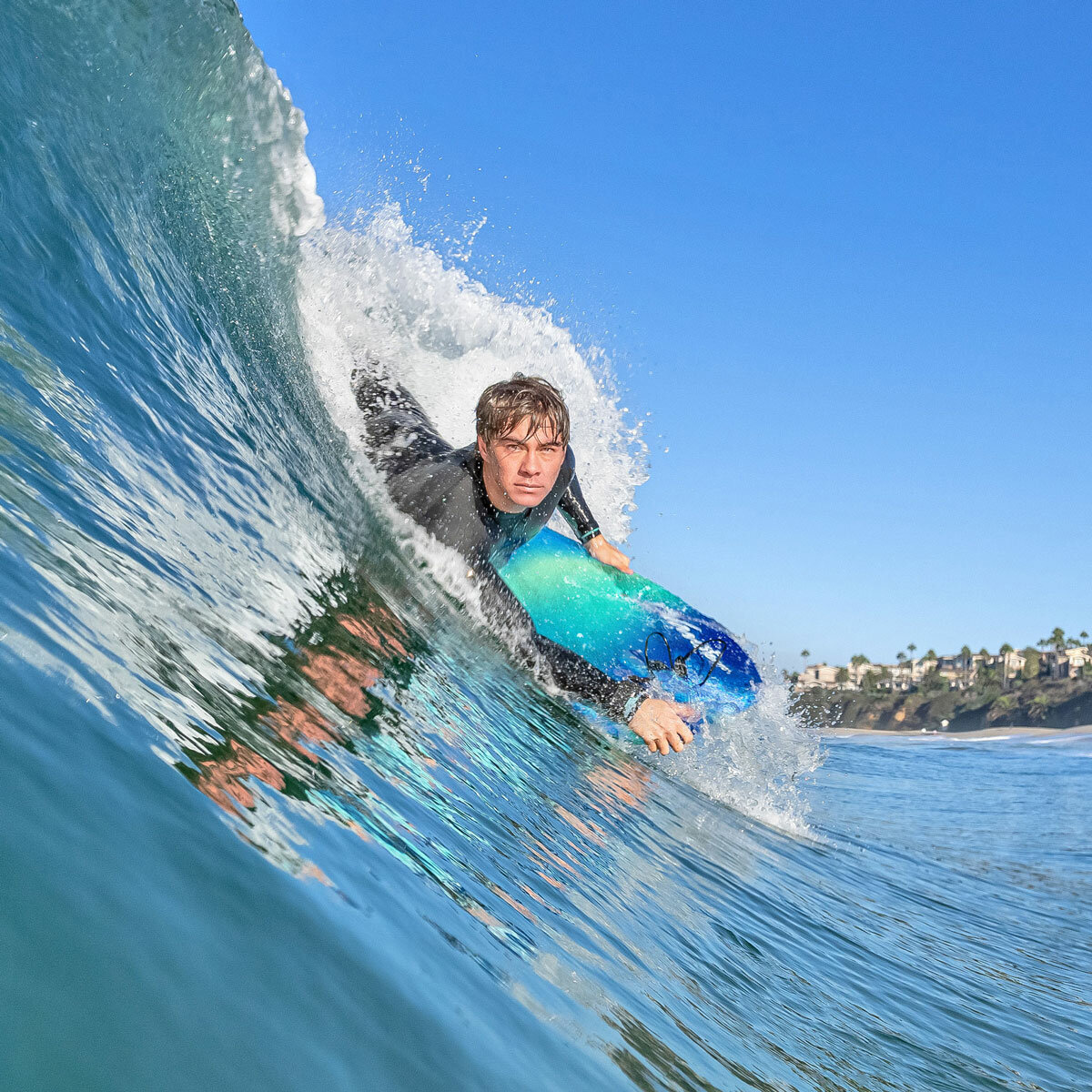 Lifestyle image of someone riding the bodyboard on a wave