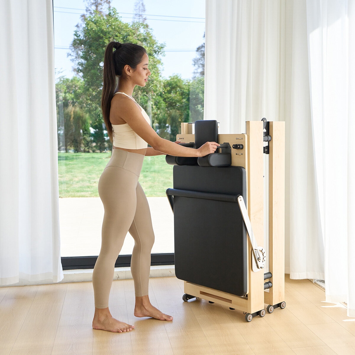 Lifestyle image of a woman folding the reformer away Lifestyle image of a woman folding the reformer away