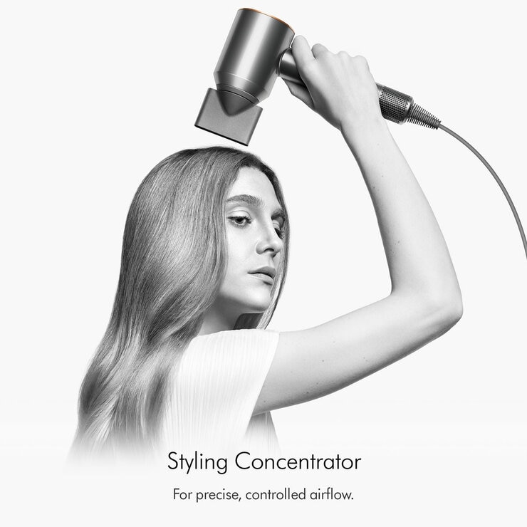 Lifestyle image of a model using Dyson Supersonic Hair Dryer's styling concentrator attachment