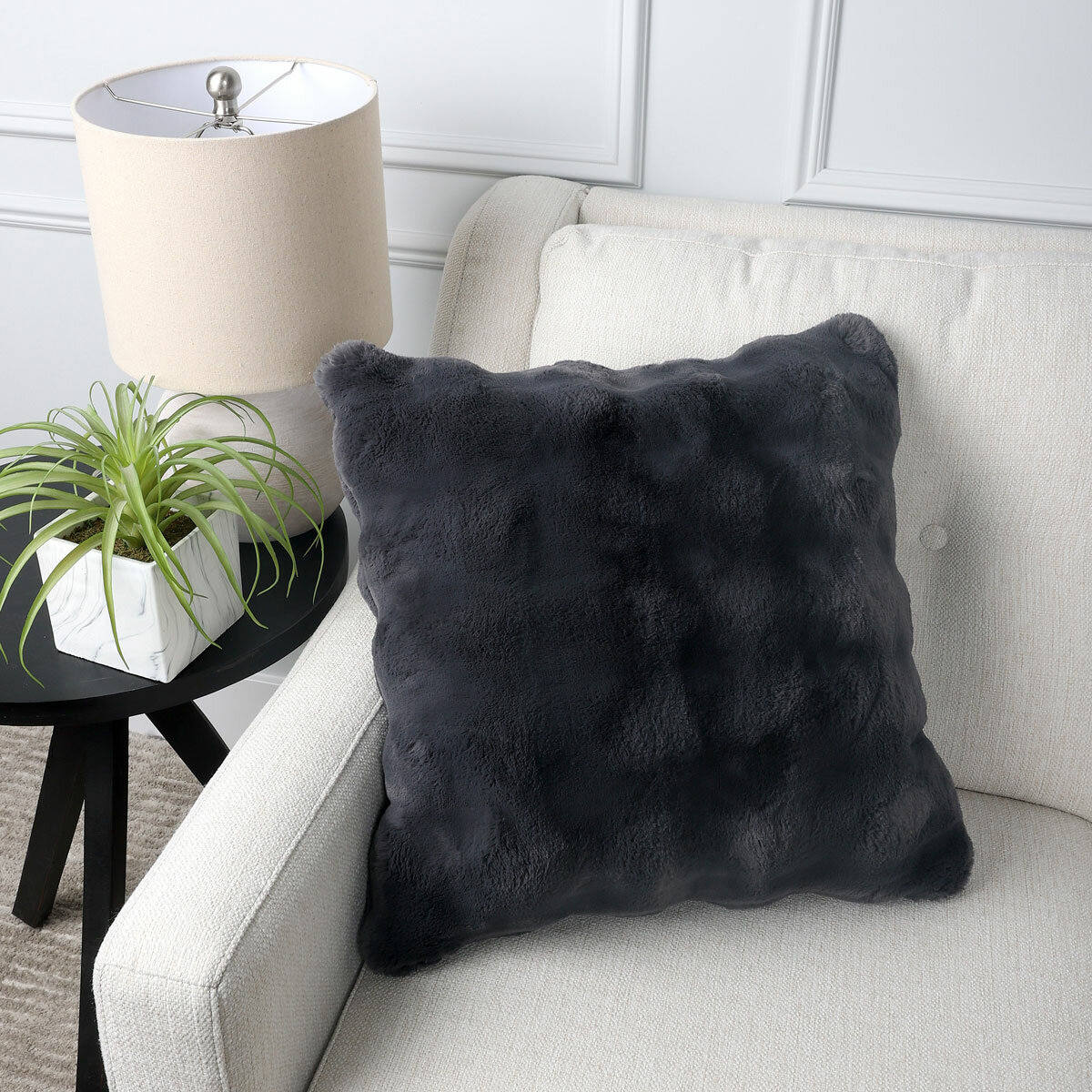Grey square cushion on a beige sofa, with a bubble texture Grey square cushion on a beige sofa, with a bubble texture