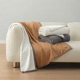 Ivory and grey throw folded on sofa with camel laid open showcasing size
