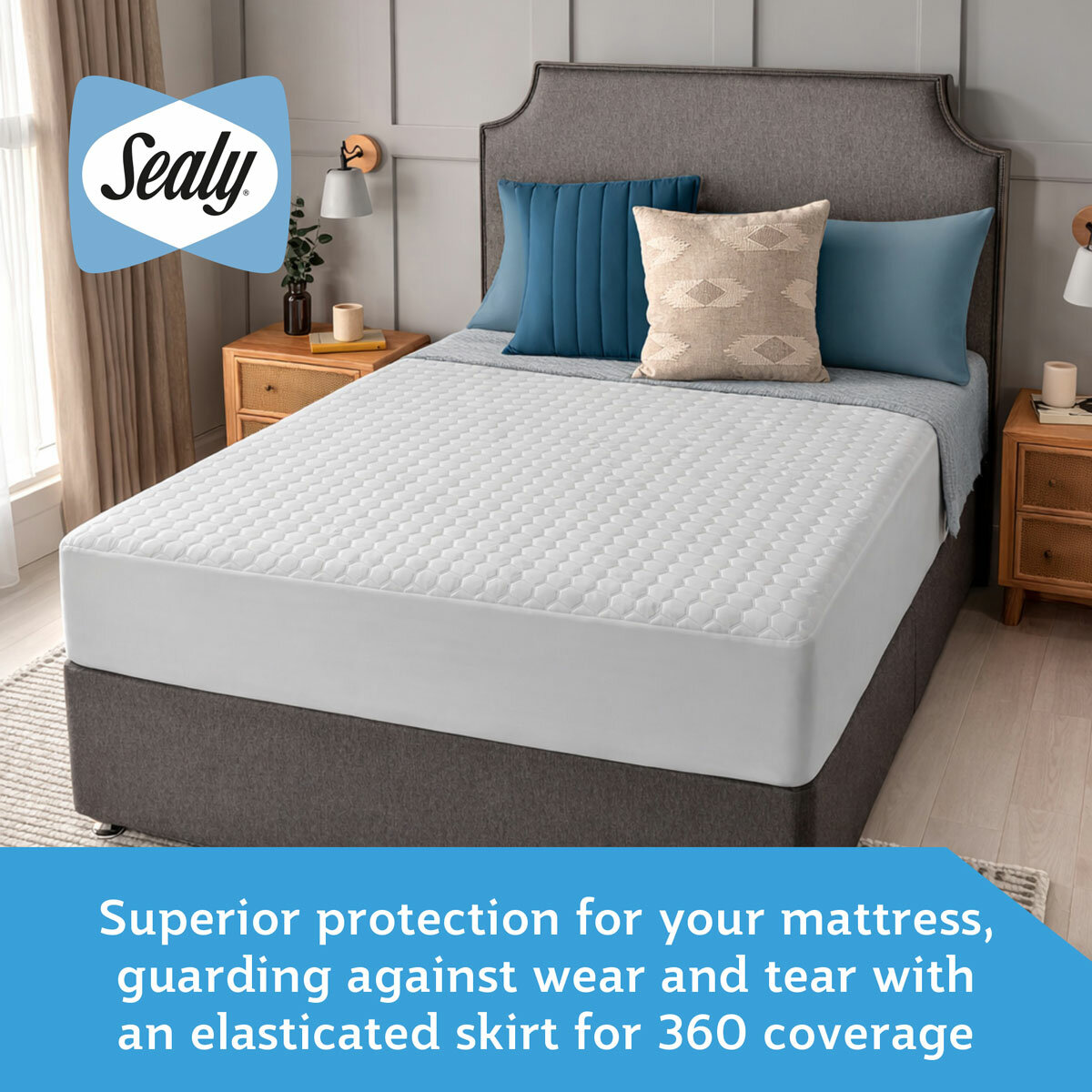A fitted white mattress protector with a hexagonal quilted pattern on a neatly made bed in a modern bedroom