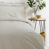 Beige and white vertically striped duvet set with matching pillowcases.