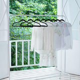 Hangers on a rail  with white clothes on wide view picture