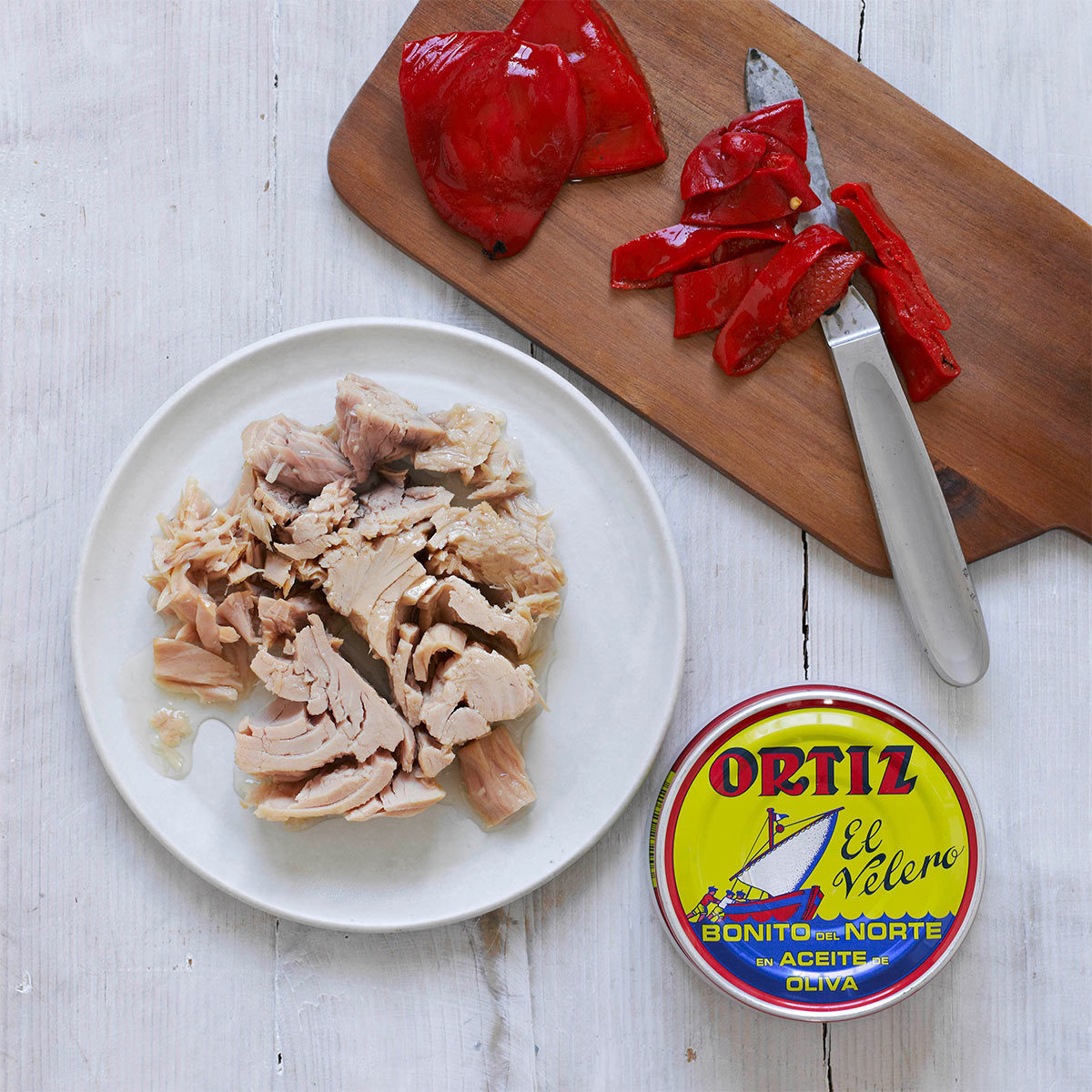 Tin of Ortiz Bonito Tuna in Olive Oil and Tuna Chunks Shown on a White Plate