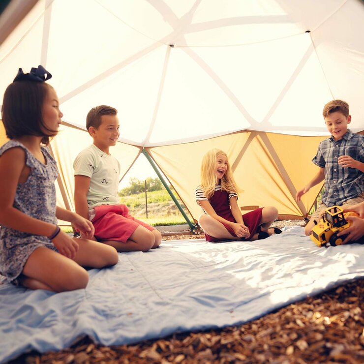 Lifestyle image of children sat under the Dome Climber with the canopy on