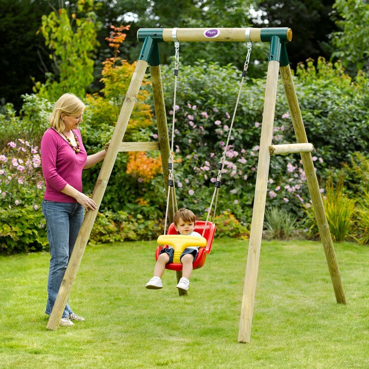 Lifestyle image of a child in the baby seat on the swing and a woman watching from the side
