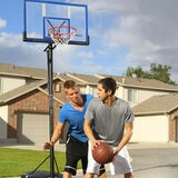 Lifestyle image of two people playing basketball with the Lifetime 48 Inch Portable Basketball Hoop in the background
