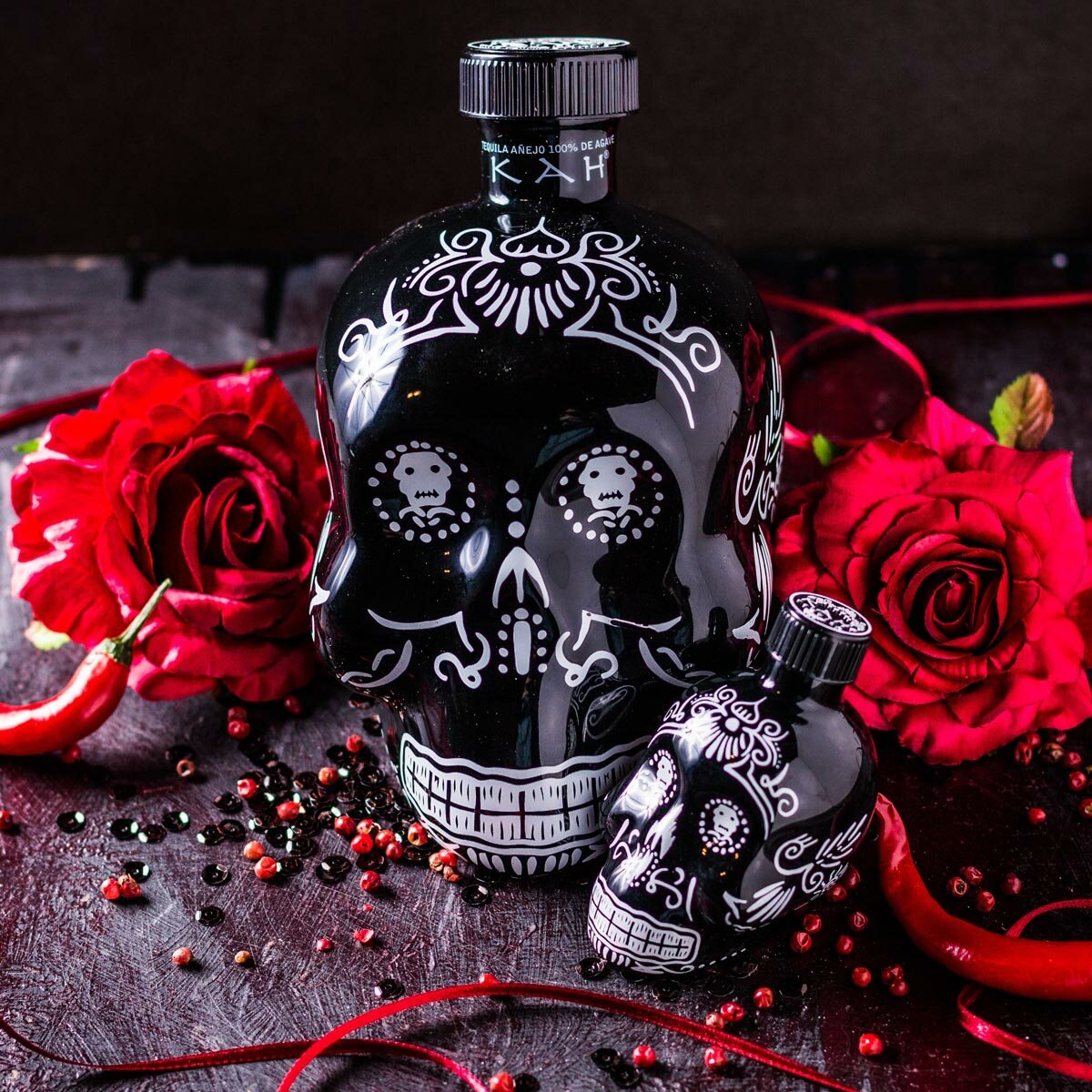 Kah Anejo Tequila Skull on a table with roses