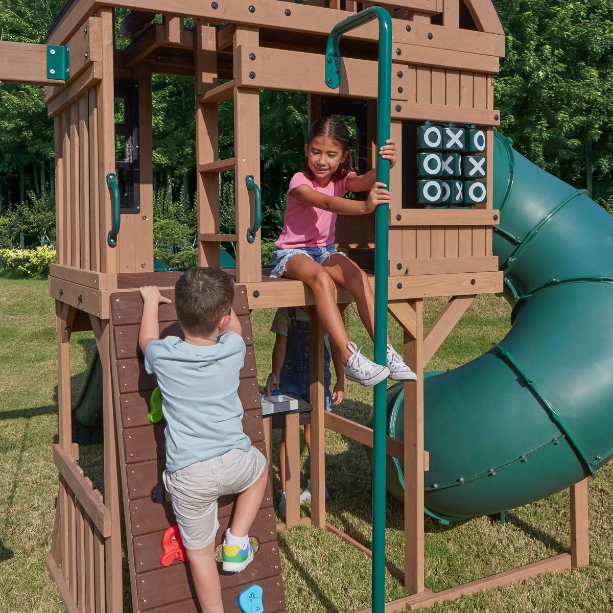 Lifestyle image of a child climbing the rock wall and another on the fireman's pole Lifestyle image of a child climbing the rock wall and another on the fireman's pole