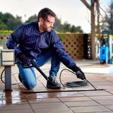 Lifestyle image of pressure washer being used to clean swimming pool